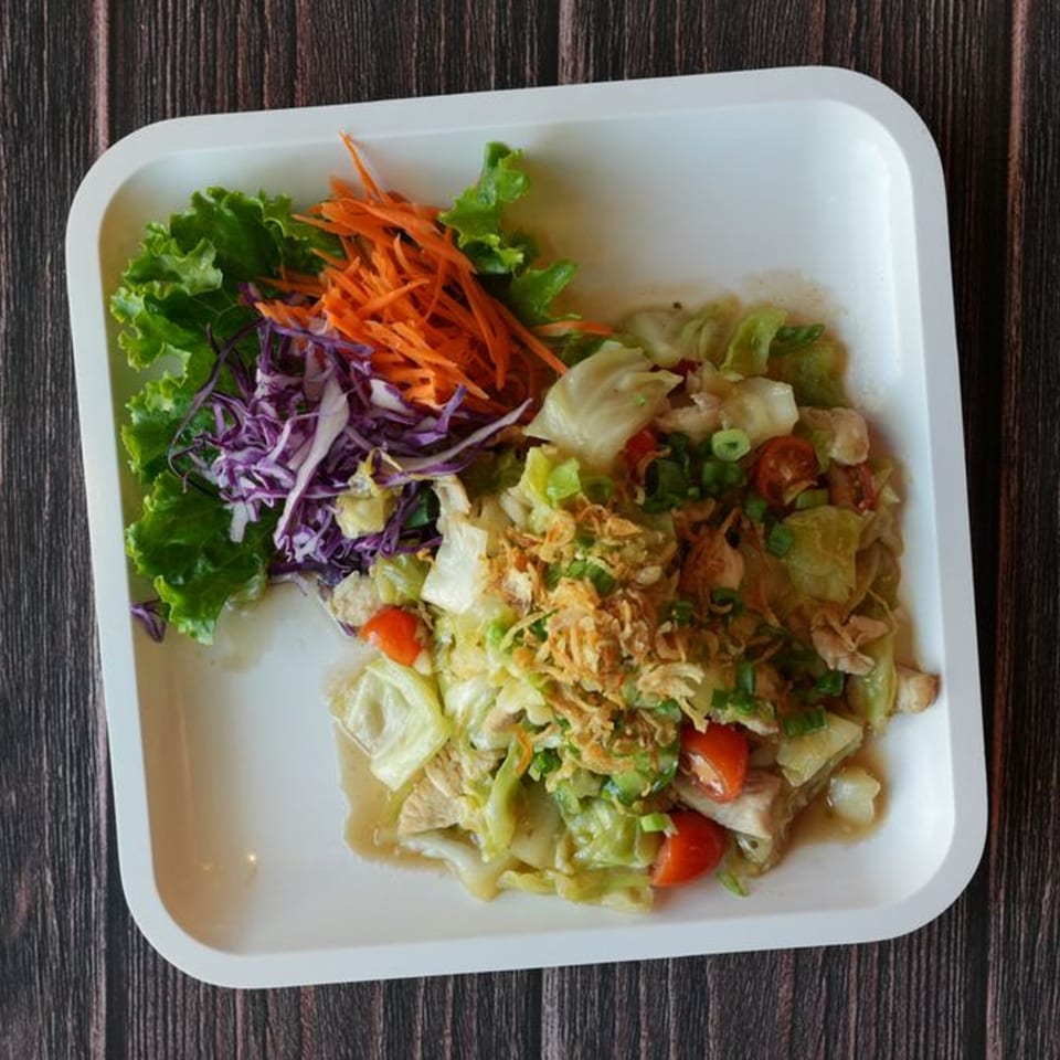 Blai Thai's chicken salad with lettuce, carrots, purple cabbage, tomatoes, and fried onions.